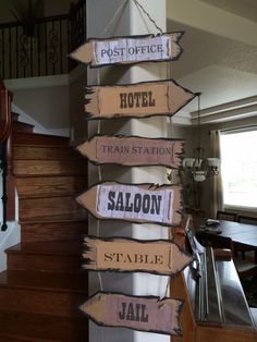 wooden signs hanging from the side of a stair case in a house with stairs leading to other rooms