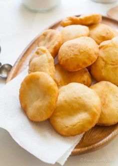 some biscuits are on a wooden plate with white napkins