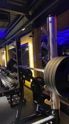 a gym with rows of exercise equipment and blue lighting