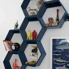 three hexagonal shelves with pictures and toys on them in the shape of hexagons