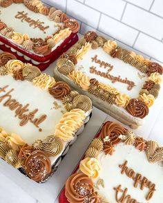 four decorated birthday cakes sitting on top of a white counter next to red and yellow boxes