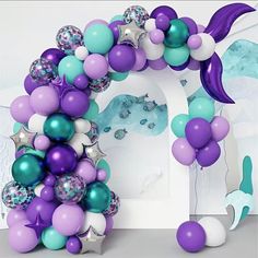 a purple and blue balloon arch with mermaid tail balloons in front of the arch is an understated door