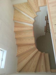 an overhead view of a spiral staircase in a house with white walls and wood floors