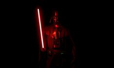 darth vader standing in the dark with two lights on his head and arms