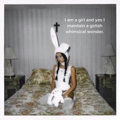 a woman sitting on top of a bed holding a stuffed animal