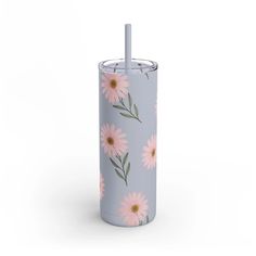 the tumbler is decorated with pink daisies and has a straw sticking out of it