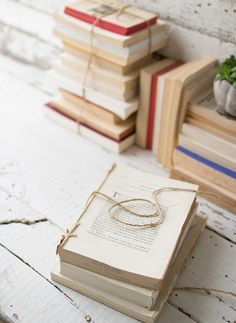 stack of books with wedding rings on them sitting in front of stacks of stacked books