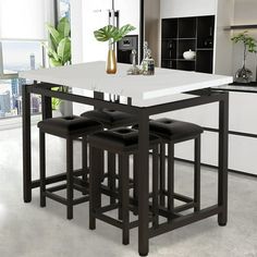 a kitchen table with four stools in front of an oven and countertop area