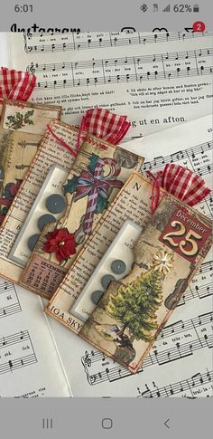 five christmas tags on top of sheet music with red ribbon and bow, surrounded by sheet music