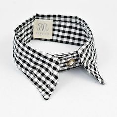 a black and white checkered bow tie with a monogrammed tag on it