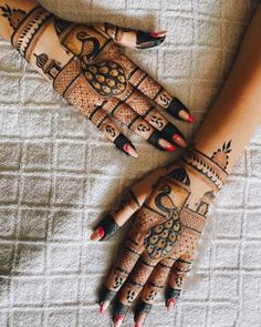 two hands with henna tattoos on them