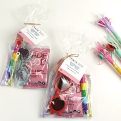 two bags with scissors, pens and markers in them on a white table next to each other