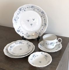 an assortment of porcelain dishes and cups on a wooden table