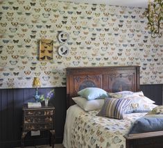 a bed sitting in a bedroom next to a wallpaper covered with butterfly designs on it