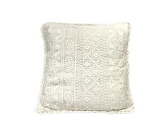 a white pillow with an intricate design on the front and back, sitting against a white background