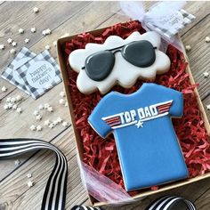 a decorated cookie in a box with sunglasses on top and an american flag tie next to it