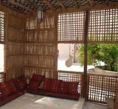 a living room filled with lots of furniture and bamboo screens on the wall behind it