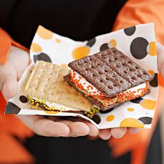 a person is holding a waffle sandwich in their hands and wearing an orange jacket