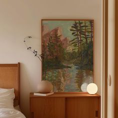 a bedroom with a painting on the wall next to a bed and nightstand in front of it