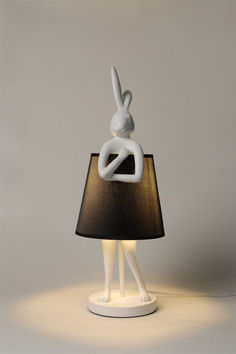 a lamp that is shaped like a person with a rabbit on it's back