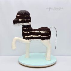 a cake shaped like a horse on top of a blue plate with white frosting