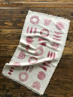 a red and white scarf on top of a wooden floor