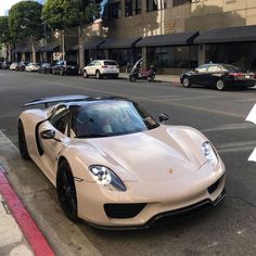 a white sports car is parked on the side of the street