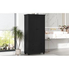 a tall black cabinet sitting in front of a bathroom window next to a potted plant