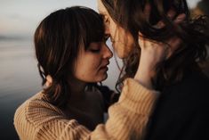 two women standing next to each other with their faces close together and looking at each other