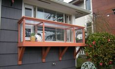 a dog is sitting on the balcony of a house