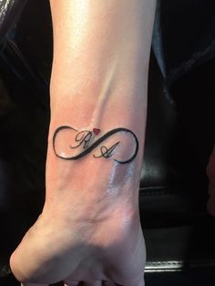 a woman's foot with a tattoo on it that has the letter e written in cursive writing