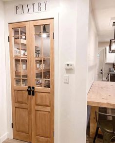 a kitchen with two wooden doors and a table in front of the door that says pantry