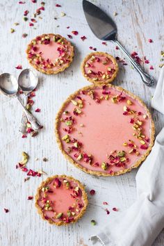 three small pies with pink frosting and sprinkles