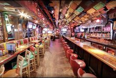 the inside of a bar with lots of tables and chairs