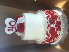 a red and white cake with flowers on it in a box for someone to decorate