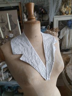 a mannequin wearing a white top with lace on it