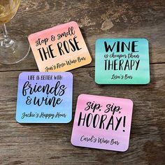 four coasters with different sayings on them sitting next to a glass of wine