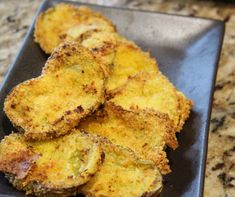 some fried food is on a black plate