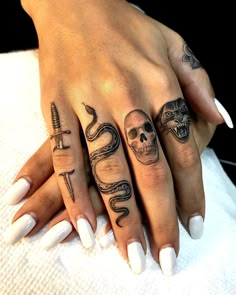 two hands with different tattoos on them, one has a snake and the other has a skull