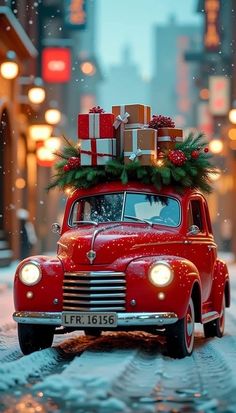 an old red car with presents on top driving down the street in the snow at night