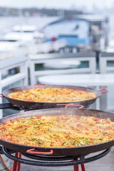 two large pans filled with food sitting on top of a metal grill next to each other