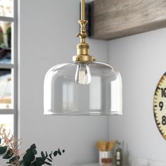 a kitchen with a clock on the wall and a light fixture hanging from the ceiling