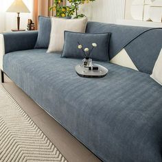 a living room with a blue couch and white pillows