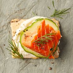 a piece of bread topped with salmon and cucumber