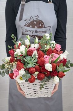 a woman holding a basket full of strawberries and flowers