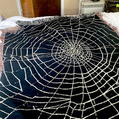 a black spider web blanket on a bed