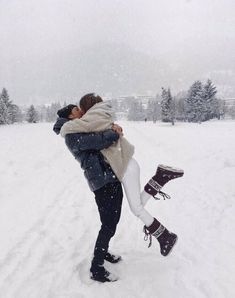 a man and woman kissing in the snow