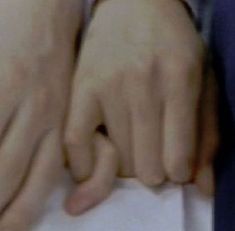 two hands are touching each other over a piece of paper