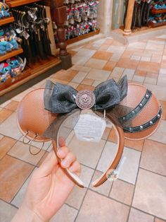 a person holding up a minnie mouse hat with a bow on it's head