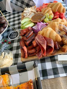 an assortment of meats and cheeses on a platter at a buffet table